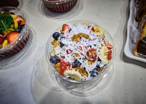 Acai bowl topped with berries, banana, and coconut shavings