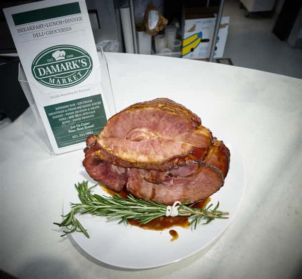 Sliced roast beef on a dish with rosemart on the side