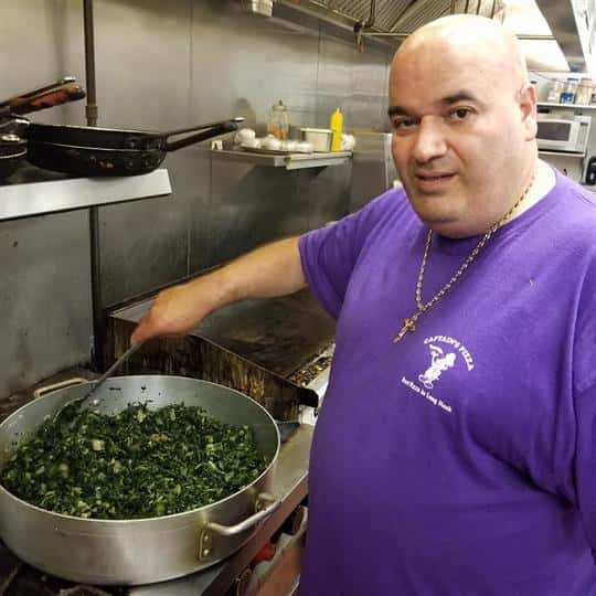 male employee stirring food in large bowl