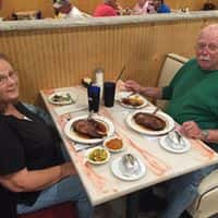 male and female sitting at a booth enjoying a meal