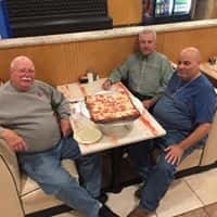three men sitting at a booth