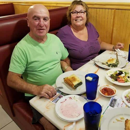 couple sitting at booth smiling for picture