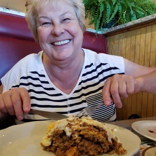female smiling cutting up food