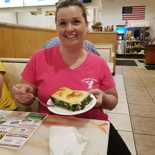 female smiling holding up entree
