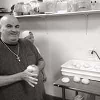 male in the kitchen rolling dough