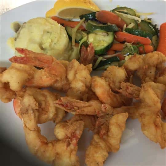 Fried shrimp with a side of mashed potatoes and vegetables