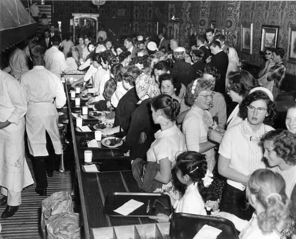 Black and white photo of people in crowded restaurant