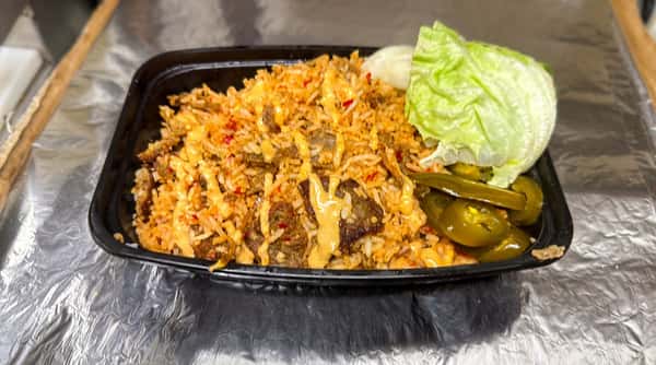 Rice pilaf with beef, hot sauce, lettuce, and jalapeño peppers in a black container on foil.