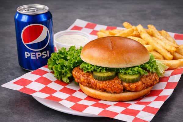 Crispy chicken sandwich combo with fries, ranch dipping sauce, and a cold Pepsi soda.
