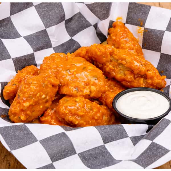 Plate of boneless buffalo chicken wings coated in glossy spicy sauce, restaurant-style comfort food.