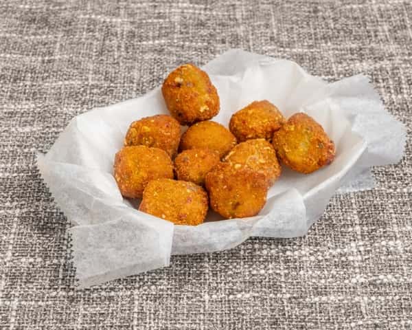 Golden crispy fried pickle chips served in a paper-lined basket, classic bar appetizer.
