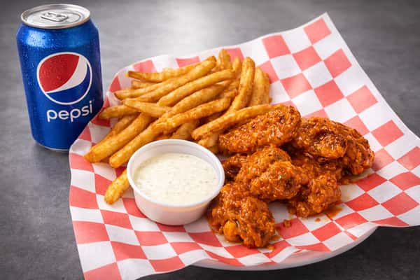 Buffalo chicken wings combo with seasoned fries, ranch dipping sauce, and a Pepsi soda.