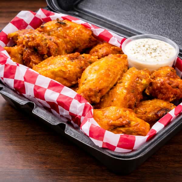 Large party platter with multiple styles of crispy chicken wings, ranch dips, celery, and carrots.