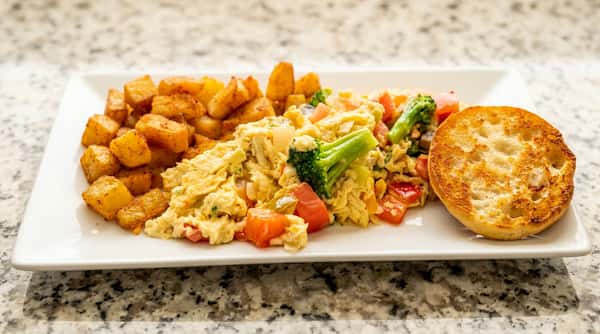 Hearty scrambled egg breakfast plate with home fries, toast, and fresh fruit at Roger's Family Restaurant in Somerset MA