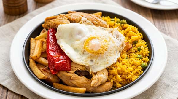 Hearty Portuguese-style steak and eggs plate with fried egg, fries, rice, and roasted pepper at Roger's Family Restaurant in Somerset MA