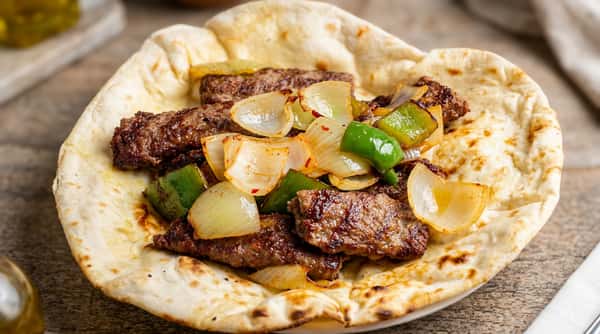 Lamb kebab plate at Sivas Tavern served with grilled vegetables, pita bread, and Mediterranean flavors