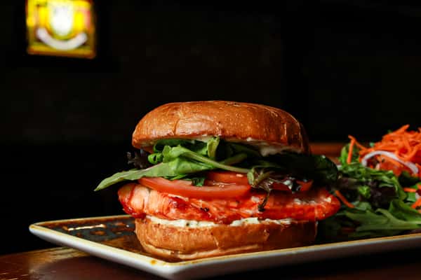 wild caught sockeye salmon, homemade tartar sauce, lettuce, tomato, on an onion bun