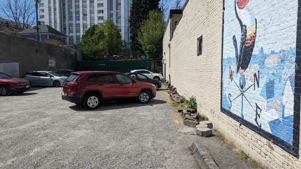 Car parked at angle a distance from a wall