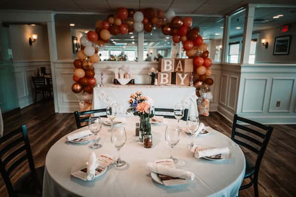 Baby shower decorations with balloon arch and gift table