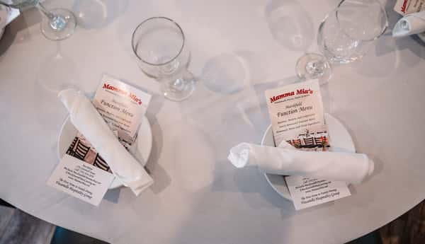 place settings with rolled linens and custom menus