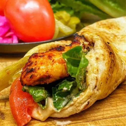 Chicken meat roll in naan with lettuce and tomato