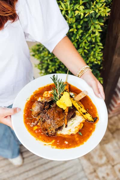 Artfully plated food with grilled meat, potatoes and roasted veggies