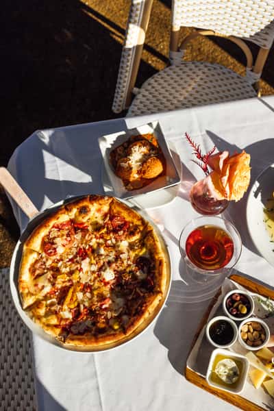 Pizza and drinks on a white tablecloth