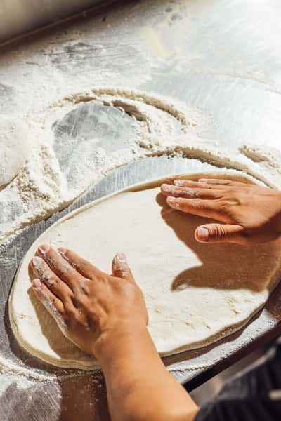 Hands stretching pizza dough