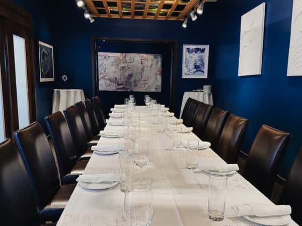 The Vineyard Room offers a sleek, glass-lined ceiling and art-filled walls, ideal for seated dinners up to 20 guests in Louisville's Westport Village.