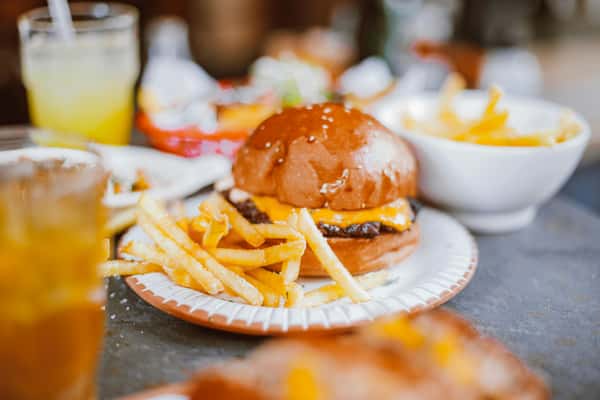 Close-up of a cheeseburger with fries on a plate, perfect for food enthusiasts.