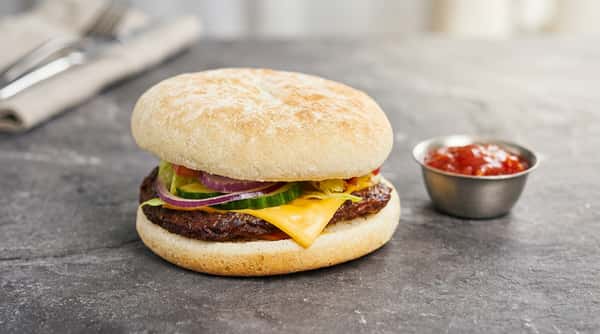 Cheeseburger with lettuce, tomato, red onion and cheese served in a soft flour-dusted bun.