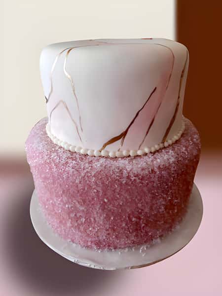 layered cake adorned with beads, gold and pink marble, and pink sugar
