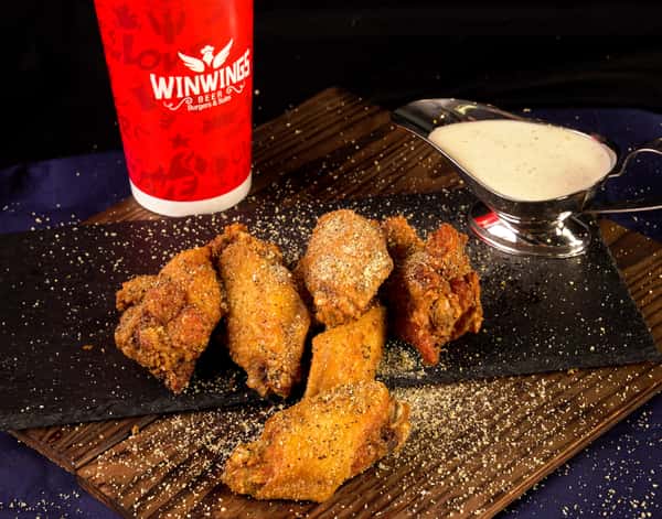 Sprinkled seasoned chicken wings with drink and sauce