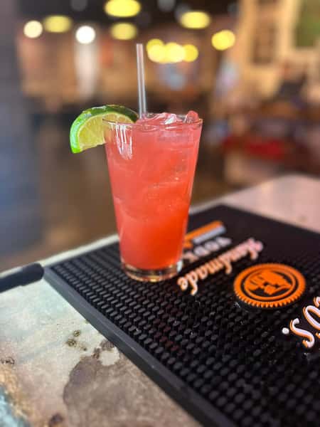 Pink cocktail with a lime wedge