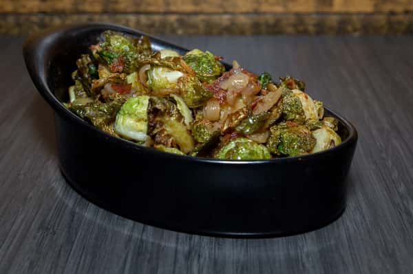 This image showcases a vibrant vegetable stir-fry, featuring broccoli and other greens tossed in a glossy sauce and topped with sesame seeds. The dish looks fresh, flavorful, and perfectly sautéed.