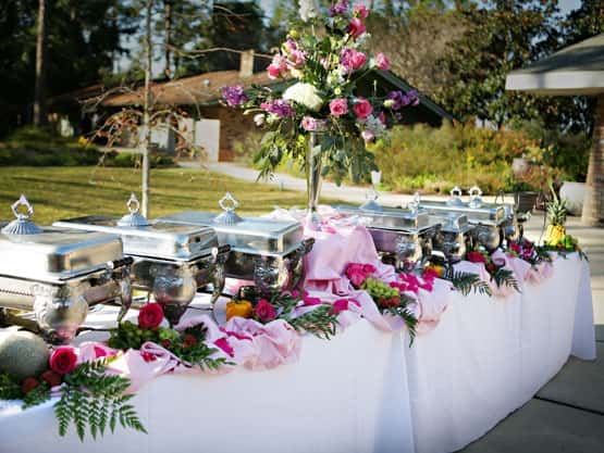 outdoor table setup for a buffet decorated with flowers