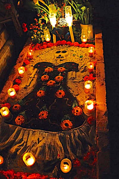 Sand mural on a gravesite during Day of the Dead in Oaxaca, MX.