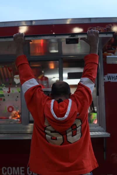 man waiting for food at food truck