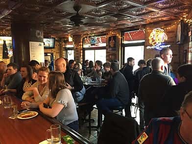 A lively group of friends toasting drinks during a private event at Clark Street Dog in Lakeview.