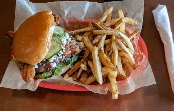 Bacon blue cheese burger with pickles and fries.