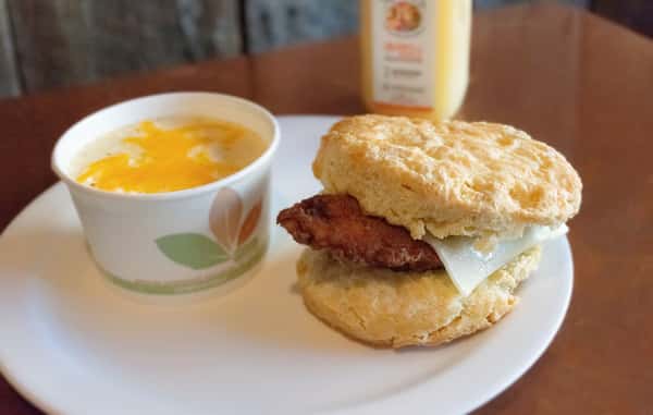 Chicken biscuit sandwich with a side of cheesy grits.