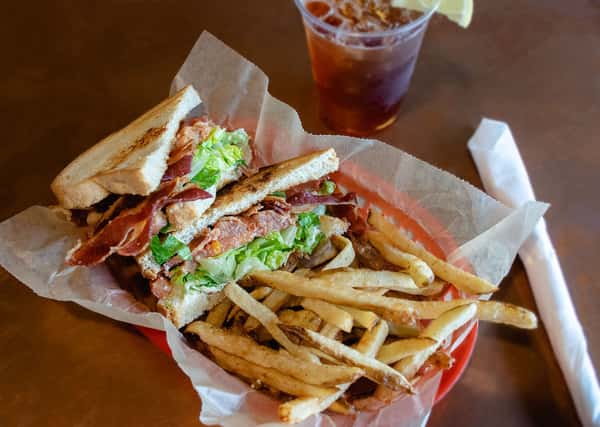Toasted club sandwich filled with crispy bacon, lettuce, tomato, and grilled chicken.