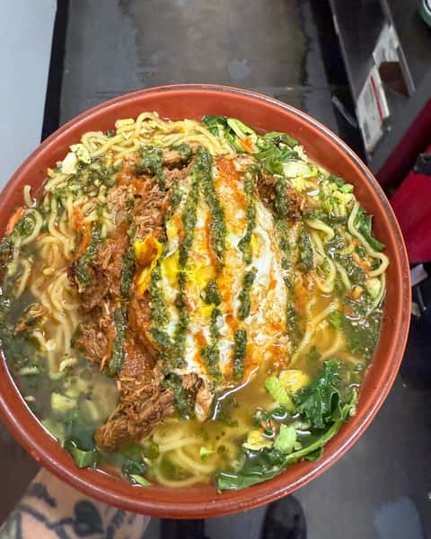 Biria Ramen has clearly become the bowl everyone keeps coming back for. 🍜 A rich pork birria ramen topped with a fried egg, mixed with cabbage and chimichurri, it's the kind of fusion favorite that doesn't just warm you up—it steals the conversation. #BiriaRamen #ColoradoGrille #RamenCravings #FusionFood