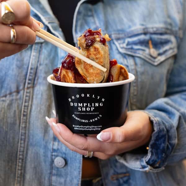 Woman using chopsticks to pick up a dumpling