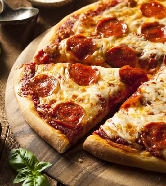 Close-up of a classic pepperoni pizza topped with melted mozzarella cheese, rich tomato sauce, and crispy pepperoni slices on a golden-brown crust.