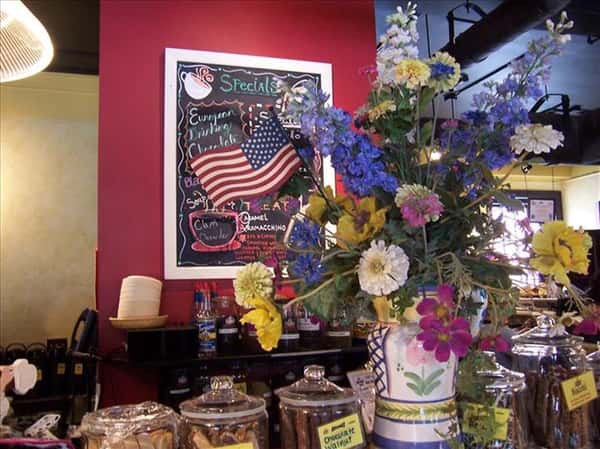 view of the counter with flowers and a menu with american flag on chalkboard
