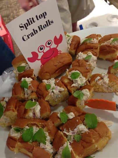 tray of crab rolls with a sign that reads split top crab rolls