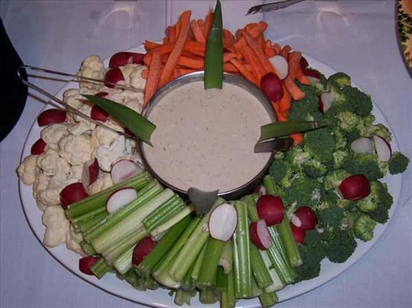 various vegetables on a plate with dipping sauce in the middle