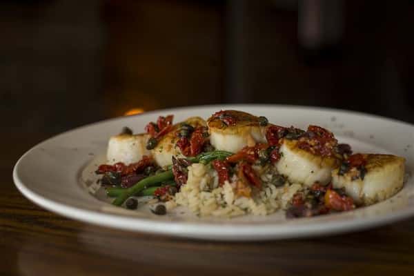 Pan Seared Scallops with sundried tomatoes, garlic, capers, basil and kalamata olives served with rice pilaf.