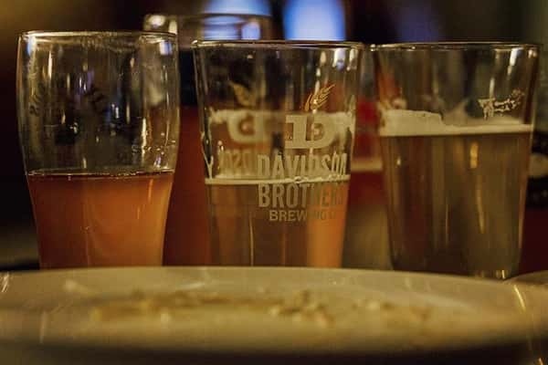 Three pints of beer on a bar top.